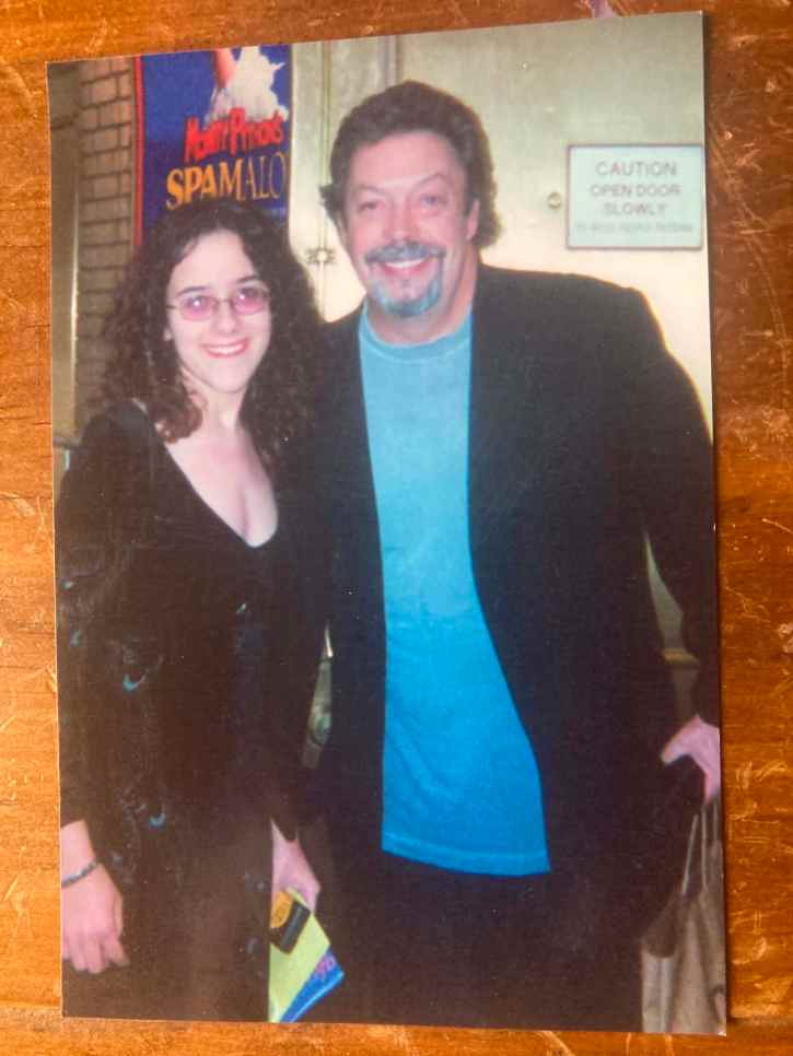 the author, Briana McGuckin, in a black velvet dress, standing with Tim Curry, at the stage door of the Shubert Theater